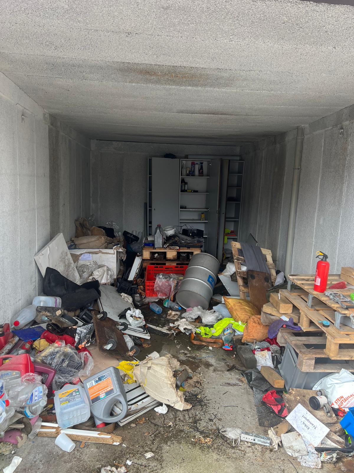 Vollgestellte Garage mit Werkzeug, Kanistern und Sperrmüll vor der Entrümpelung
